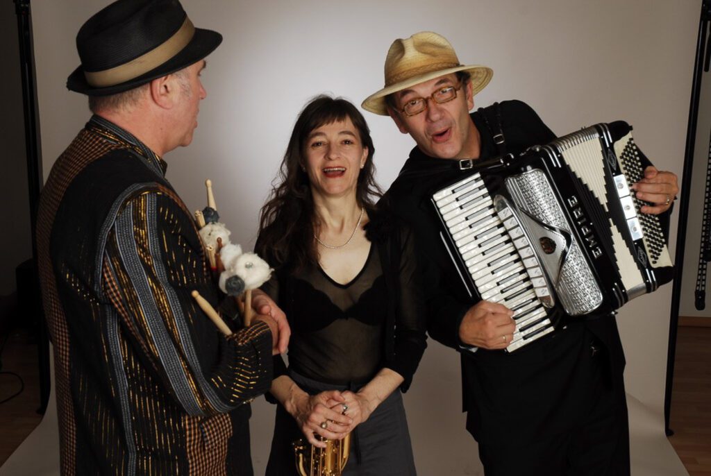 Musiktrio mit Akkordeon, Trompete und Percussion präsentiert lebendige Live-Musik mit vielfältigen Stilrichtungen